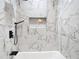 Close up of the luxurious white marble look tile shower with built in shelf at 7140 Teaberry St, Englewood, FL 34224