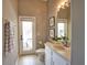 Bathroom with outdoor access featuring single vanity, neutral walls, and tile flooring at 8209 Snowy Egret Pl, Bradenton, FL 34202