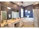 Beautiful bathroom with a tub, shower, and dual sinks featuring neutral tile and a modern light fixture at 8209 Snowy Egret Pl, Bradenton, FL 34202