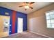 Cozy bedroom with a unique two-tone blue and tan color scheme and a ceiling fan with lights at 8209 Snowy Egret Pl, Bradenton, FL 34202