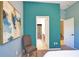 Bright bedroom featuring neutral carpet, blue accent wall, and multiple entryways at 8209 Snowy Egret Pl, Bradenton, FL 34202