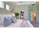Primary bedroom with bathroom and closet access, featuring a tray ceiling and light green walls at 8209 Snowy Egret Pl, Bradenton, FL 34202