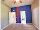 Bedroom featuring neutral carpet, blue accent wall, and multiple entryways at 8209 Snowy Egret Pl, Bradenton, FL 34202