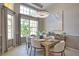 Elegant dining room featuring stylish chandelier, modern decor, and bright natural light from large windows at 8209 Snowy Egret Pl, Bradenton, FL 34202