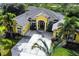 Beautifully landscaped home with lush greenery, a circular driveway, and a spacious three-car garage at 8209 Snowy Egret Pl, Bradenton, FL 34202
