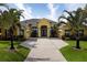 Inviting single-story home with a sunny yellow facade, lush palm trees, and an expansive driveway at 8209 Snowy Egret Pl, Bradenton, FL 34202