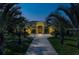 Elegant home with lush landscaping and an inviting walkway at dusk at 8209 Snowy Egret Pl, Bradenton, FL 34202