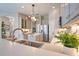 Modern kitchen featuring stainless steel appliances, center island, and quartz countertops under a stylish light fixture at 8209 Snowy Egret Pl, Bradenton, FL 34202