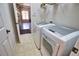 Well-lit laundry room featuring modern, front-loading washer and dryer set at 8209 Snowy Egret Pl, Bradenton, FL 34202
