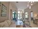 Open living room with neutral tones, tile flooring, and lots of natural light from front door at 8209 Snowy Egret Pl, Bradenton, FL 34202