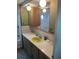 Bathroom with a yellow sink, green cabinets, and a large mirror reflecting the shower and tub at 834 Cervina S Dr, Venice, FL 34285