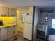 Functional kitchen featuring white appliances, laminate counters and floors, and neutral cabinets at 834 Cervina S Dr, Venice, FL 34285