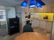 Bright kitchen with white cabinets, complete with essential appliances, and adjacent dining area at 834 Cervina S Dr, Venice, FL 34285