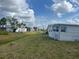 Mobile home community street view with green spaces and tidy lawns at 834 Cervina S Dr, Venice, FL 34285