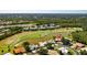 Aerial view of neighborhood homes situated along a golf course and ponds at 838 Carnoustie Dr, Venice, FL 34293