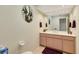 Bathroom with a double sink vanity, decorative mirror, and neutral decor at 838 Carnoustie Dr, Venice, FL 34293