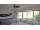 Bright bedroom with a large bay window offering lush landscaping views and a decorative ceiling fan at 838 Carnoustie Dr, Venice, FL 34293