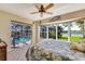 Bright bedroom with a pool view through sliding doors, a bay window, and a decorative ceiling fan at 838 Carnoustie Dr, Venice, FL 34293