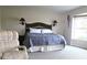 Well-lit bedroom features a comfortable armchair, decorative lamps and bay window with great natural light at 838 Carnoustie Dr, Venice, FL 34293