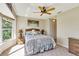 Cozy bedroom featuring a ceiling fan, a large window, and closet storage at 838 Carnoustie Dr, Venice, FL 34293