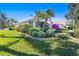 Beautiful single-story home with manicured landscaping including various trees and bushes at 838 Carnoustie Dr, Venice, FL 34293