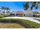 Charming single-story home boasts a well-manicured lawn and lush landscaping at 838 Carnoustie Dr, Venice, FL 34293