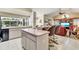 Kitchen with island seating that flows into a living room with a large window at 838 Carnoustie Dr, Venice, FL 34293