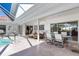 Covered patio with dining set and lounge seating, flowing seamlessly from the pool area at 838 Carnoustie Dr, Venice, FL 34293