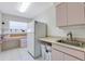 Bright laundry room with desk, sink, plenty of storage, and white appliances at 838 Carnoustie Dr, Venice, FL 34293