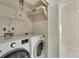 Convenient laundry room with front-loading washer and dryer and shelving storage at 838 Carnoustie Dr, Venice, FL 34293