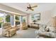 Comfortable living room featuring plush seating, a bay window, and a decorative ceiling fan at 838 Carnoustie Dr, Venice, FL 34293