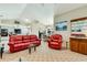 Open concept living room with red leather furniture, kitchen access and vaulted ceiling at 838 Carnoustie Dr, Venice, FL 34293