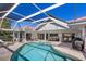 Relaxing pool area with lounge furniture, grill, and screened enclosure for outdoor enjoyment at 838 Carnoustie Dr, Venice, FL 34293