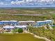 Wide aerial shot of condo community by a pond, showing lush landscaping and colorful residential buildings at 8409 Placida Rd # 206, Placida, FL 33946