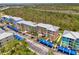 Aerial view showcasing a condo complex with vibrant buildings, covered parking, and palm-lined parking areas at 8409 Placida Rd # 206, Placida, FL 33946