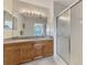 Bright bathroom featuring double vanity with granite countertop and glass enclosed shower at 8409 Placida Rd # 206, Placida, FL 33946