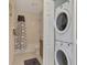 Compact bathroom with shower-tub, stacked washer and dryer, and neutral tile at 8409 Placida Rd # 206, Placida, FL 33946