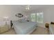 Bright bedroom with fan and window overlooking beautiful trees at 8409 Placida Rd # 206, Placida, FL 33946