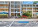 Condo entrance showcasing walkways, tropical plants, and building access points with parking nearby at 8409 Placida Rd # 206, Placida, FL 33946