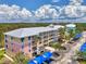 Side view of colorful condo with covered parking, landscaped grounds, and vibrant exterior paint scheme at 8409 Placida Rd # 206, Placida, FL 33946