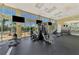 Bright gym featuring modern equipment, flat-screen TVs, and large windows with scenic views at 8409 Placida Rd # 206, Placida, FL 33946