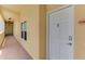 Condo hallway with door featuring a modern electronic lock, and natural light from a nearby window at 8409 Placida Rd # 206, Placida, FL 33946
