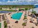 Aerial view of the rectangular community pool with lounge chairs on brick patio, set amongst palm trees at 8409 Placida Rd # 206, Placida, FL 33946