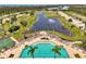 Aerial view of a large community pool and water feature surrounded by lush landscaping and lounge chairs at 8409 Placida Rd # 206, Placida, FL 33946