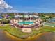 Aerial shot showcasing the community pool, clubhouse, and surrounding greenery with a view of a lake at 8409 Placida Rd # 206, Placida, FL 33946