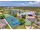 Aerial view of community tennis and pickleball courts with clubhouse and lush landscaping in the background at 8409 Placida Rd # 206, Placida, FL 33946