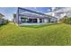 A manicured lawn and a screened in pool offer a view from the canal at 8634 Santa Cruz Dr, Port Charlotte, FL 33981