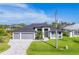 An elevated view showcasing a modern home with a three-car garage and lush green lawn at 8634 Santa Cruz Dr, Port Charlotte, FL 33981