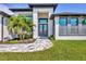 Close up of front entrance featuring large double-door entry, gray brick walkway, and minimalist landscaping at 8634 Santa Cruz Dr, Port Charlotte, FL 33981