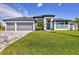 A modern two-story home with a well-manicured lawn, three-car garage, and stylish gray accents at 8634 Santa Cruz Dr, Port Charlotte, FL 33981